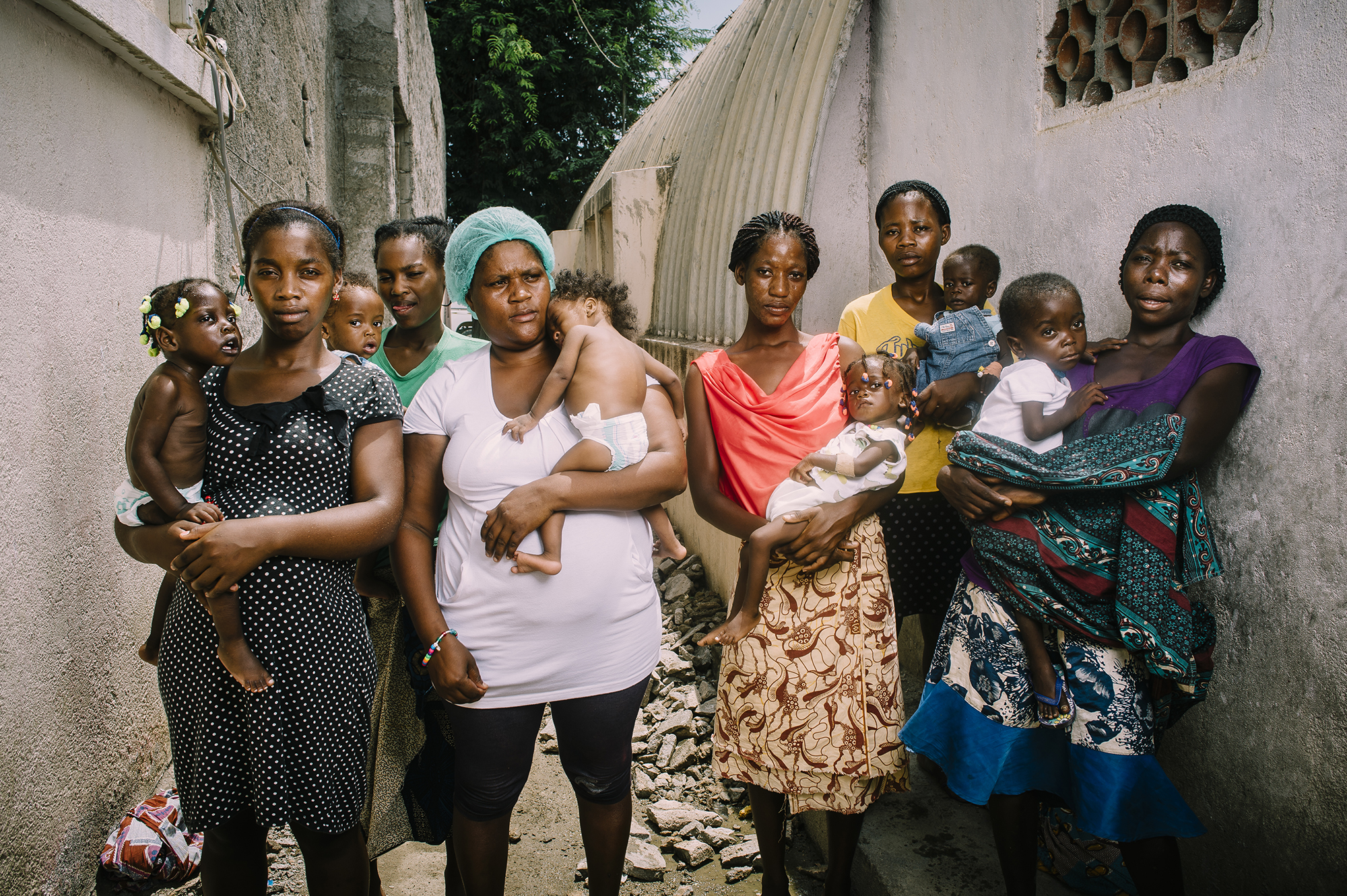 Mothers and their malnourished infants in a malnutrition clinic, showcasing community support and care during recovery in Angola.