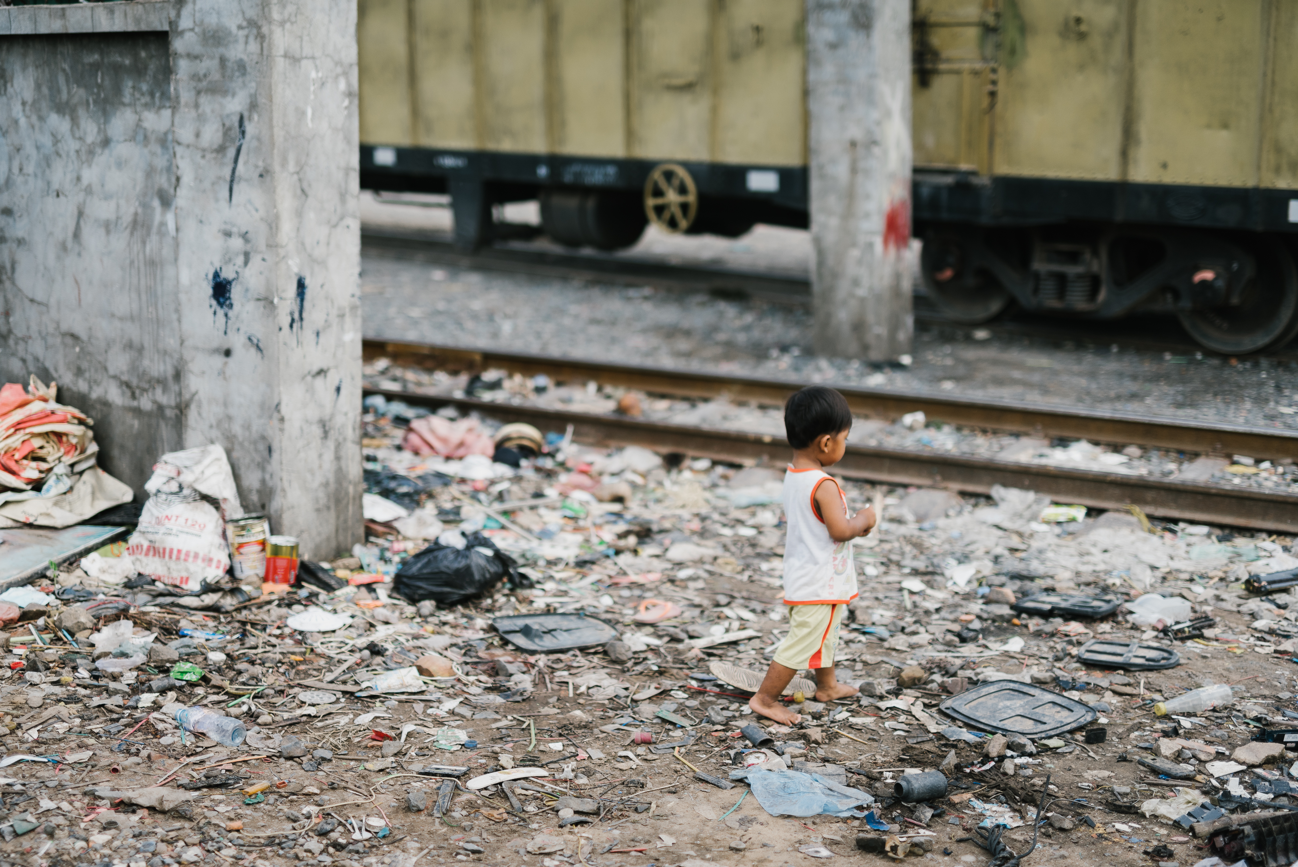 NightCare Team Trip - a toddler boy walking barefoot in a pile of trash.