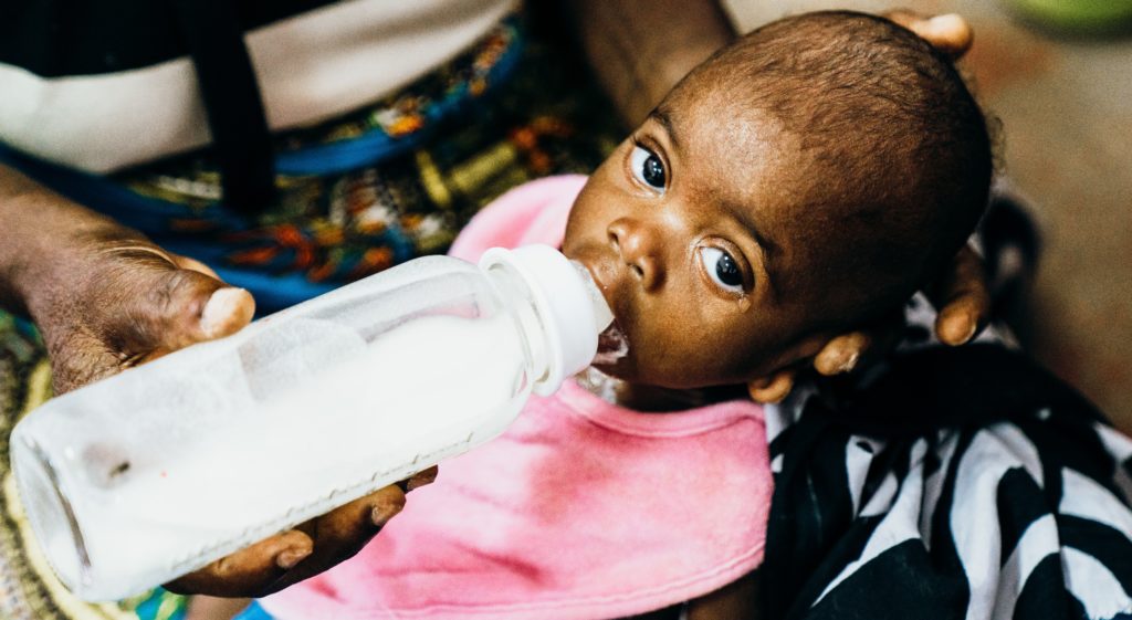 From Bad to Worse - A baby girl in Angola being fed therapeutic milk to treat her malnutrition. 