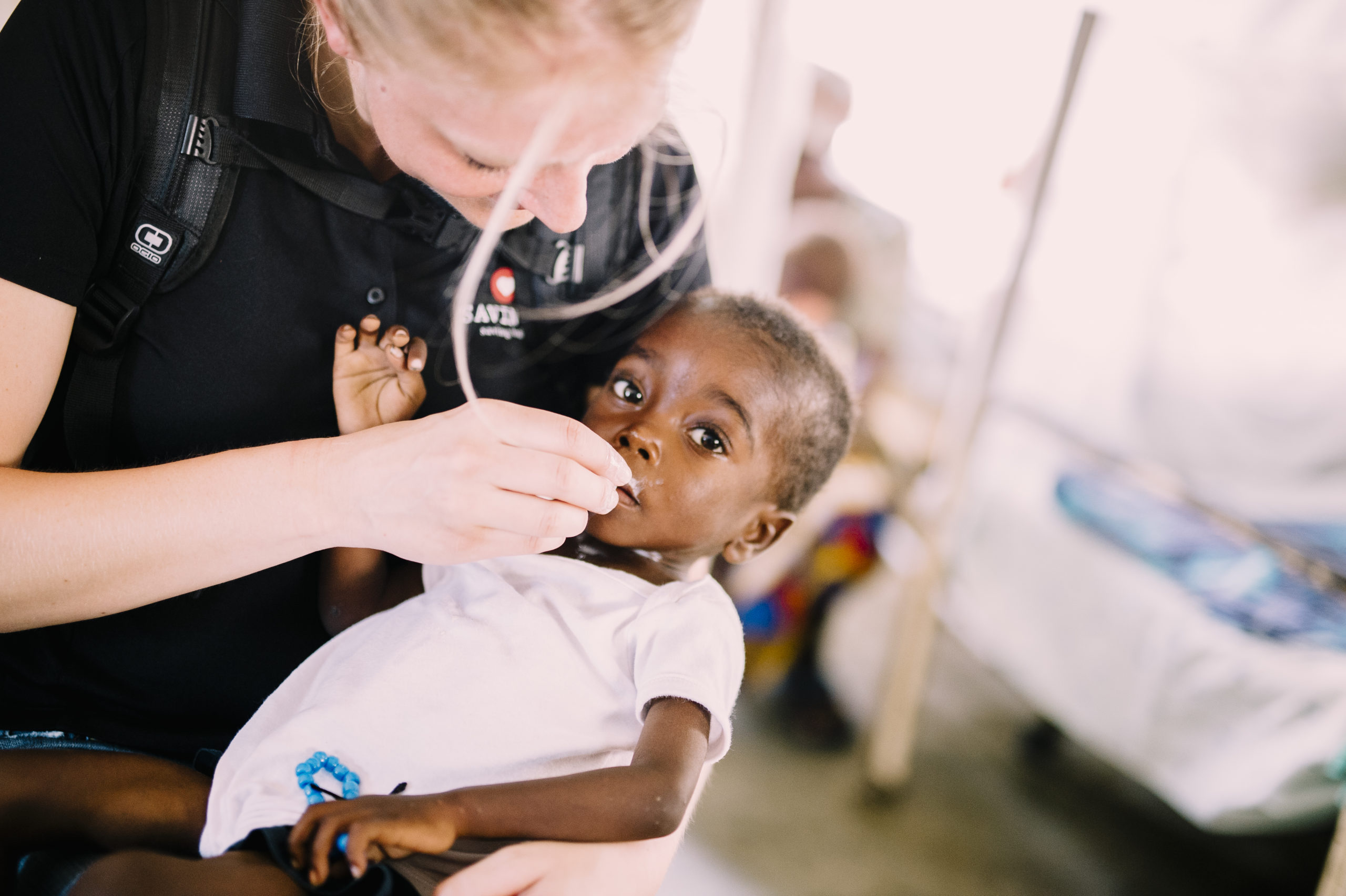 Why Should I Care About Babies Across the World? Executive Director, Heidi Cortez, feeding therapeutic milk to a malnourished baby in Angola.