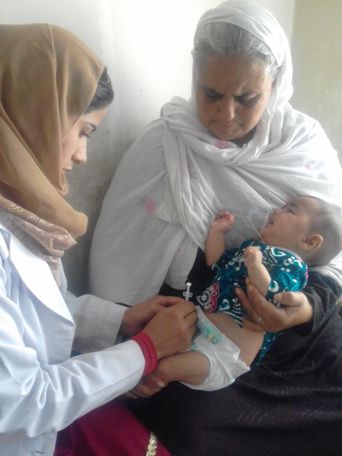 A female doctor tending to a baby and its mother in the Saving Moses BirthAid