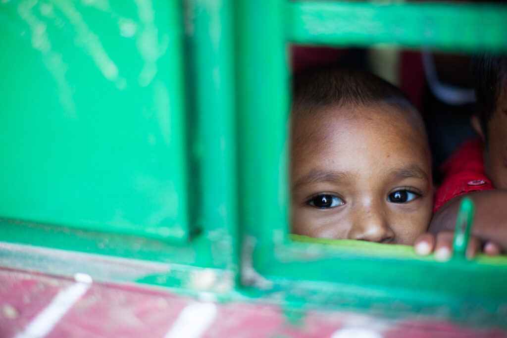 a toddler looks through the window of one of the Saving Moses NightCare centers