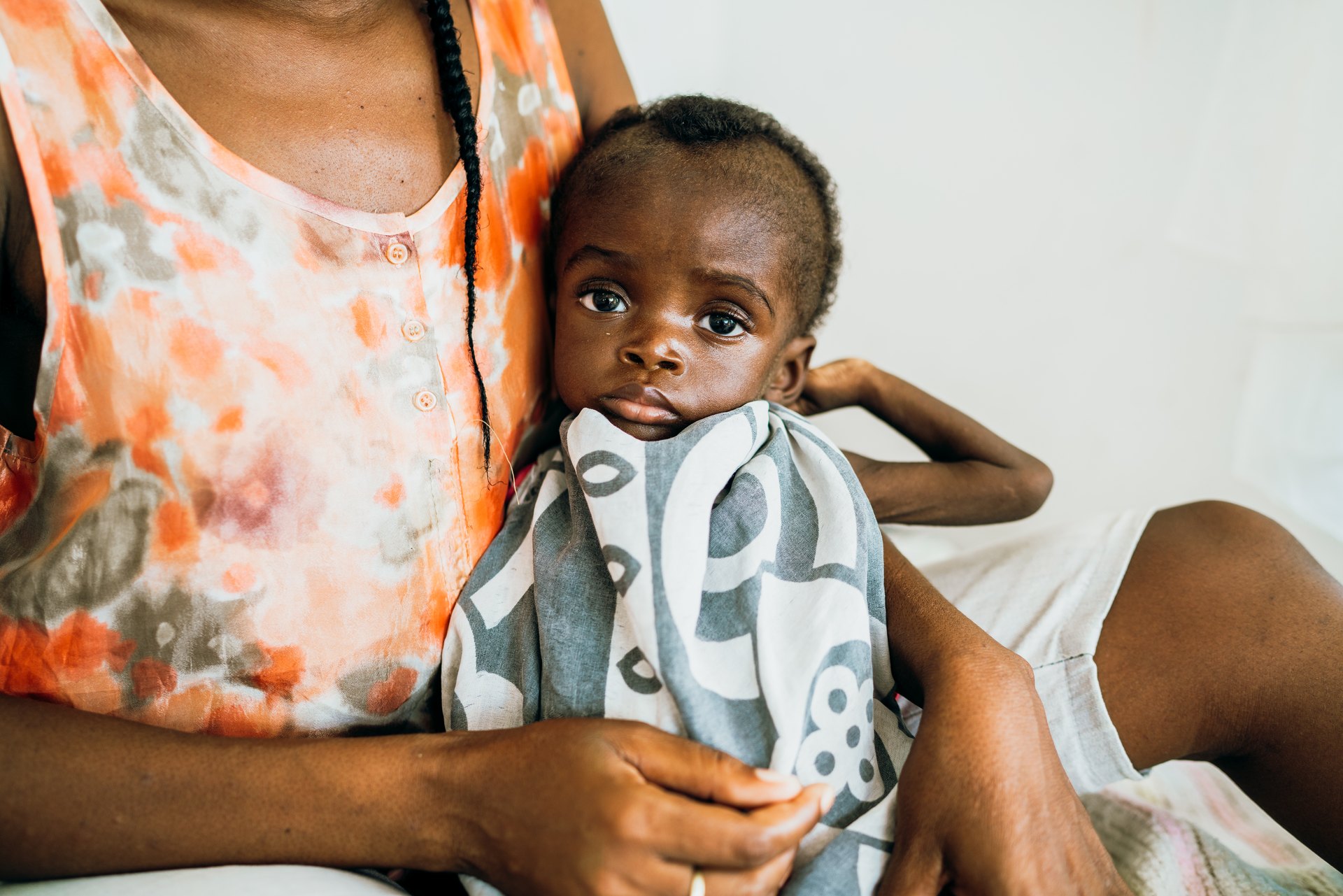A baby wrapped in a blanket in a caregiver’s arms
