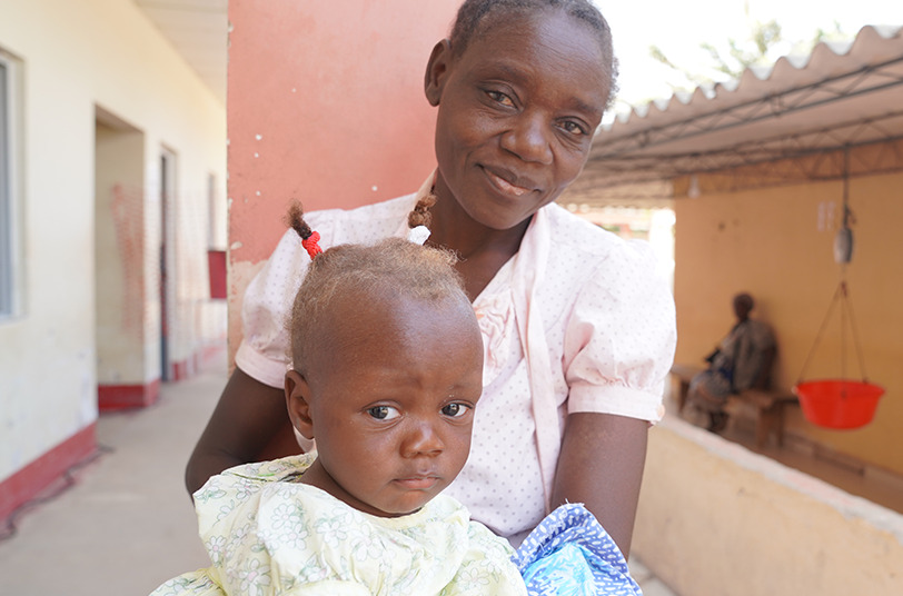 Mother holding infant in a supportive environment, emphasizing care and connection related to Saving Moses' BirthAid initiative for infants in Sub-Saharan Africa.