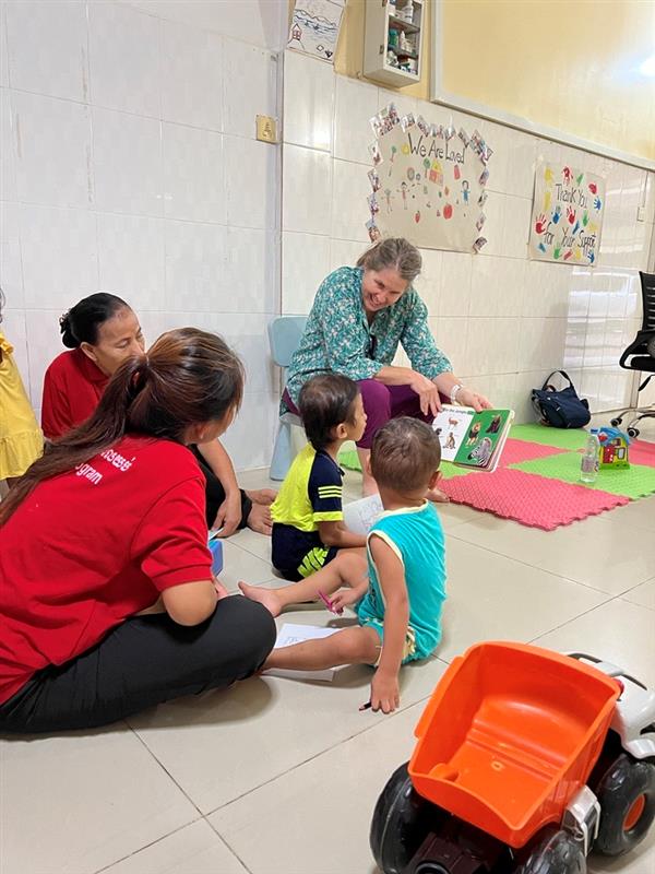 Children engaging in storytime with a facilitator in a colorful learning environment, promoting early childhood education and care.