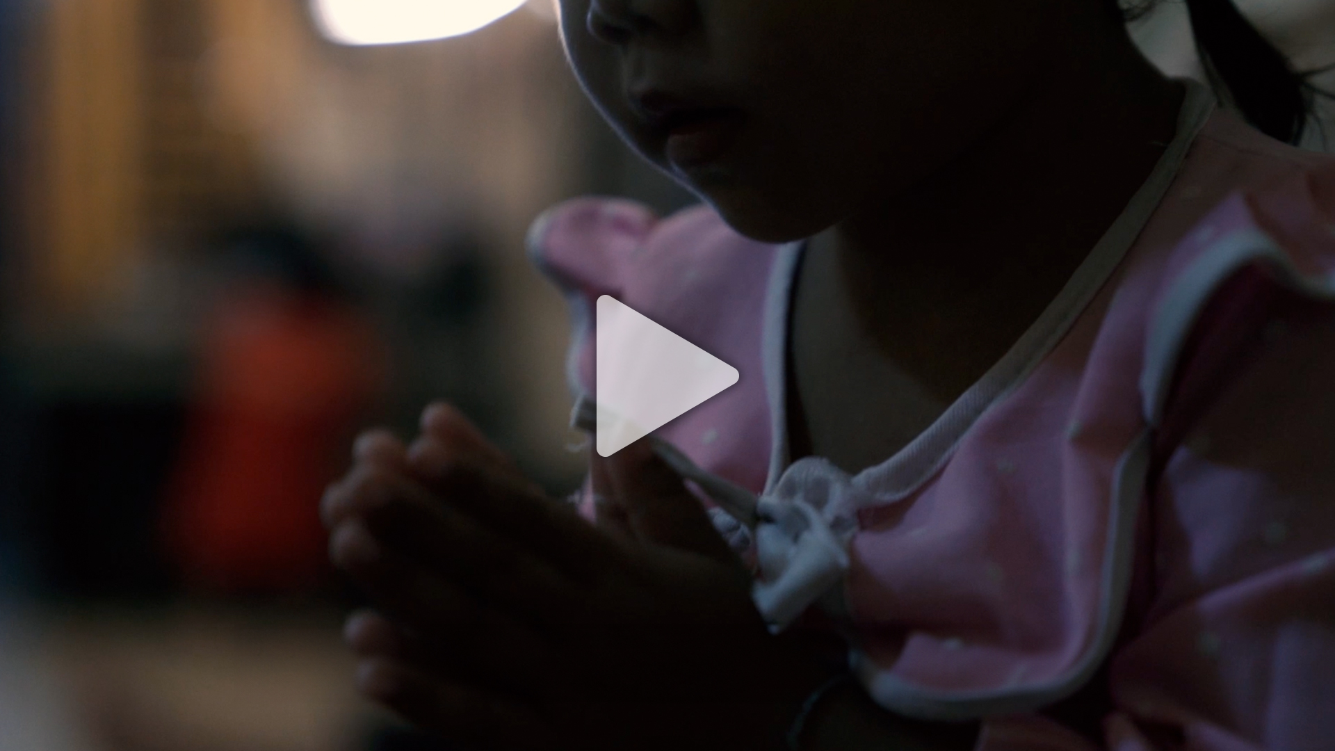 Child in pink clothing with clasped hands, symbolizing hope and care for vulnerable children supported by Saving Moses' NightCare program.