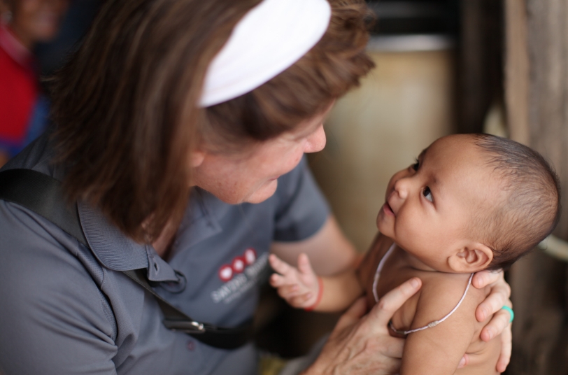 Woman interacting lovingly with a baby, emphasizing care and connection, relevant to Saving Moses' mission to support vulnerable children in Southeast Asia.
