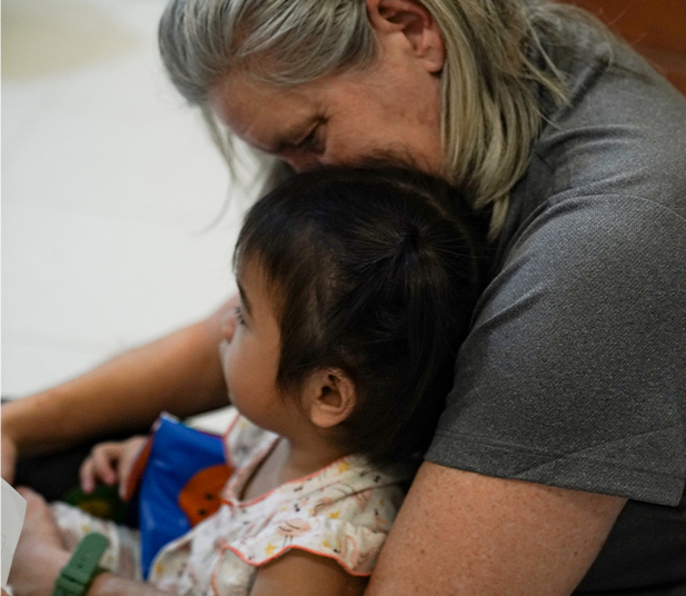 Woman embracing a young child, showcasing love and care in a nurturing environment, emphasizing the mission of Saving Moses to support vulnerable children.